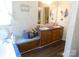 Well-lit bathroom with double sinks, a bench, and a bathtub at 33343 Old Salisbury Rd, Albemarle, NC 28001