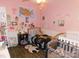 Pink bedroom with two beds, a US map, ceiling fan and white wainscoting at 33343 Old Salisbury Rd, Albemarle, NC 28001