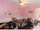 Pink bedroom featuring two cribs, a ceiling fan, and decorative wall art at 33343 Old Salisbury Rd, Albemarle, NC 28001