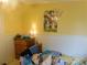 Bedroom featuring yellow walls, wainscoting, and a Bluey poster at 33343 Old Salisbury Rd, Albemarle, NC 28001