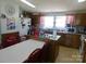 Country kitchen with wood cabinets, a white refrigerator, an island and a dining area with red chairs at 33343 Old Salisbury Rd, Albemarle, NC 28001