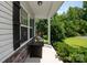Covered porch area featuring a hanging swing chair and stone-accented wall at 389 Whispering Hills Dr, Locust, NC 28097