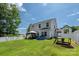 Spacious backyard with a two-story house, a gazebo, play set, a white fence and lush green grass at 389 Whispering Hills Dr, Locust, NC 28097