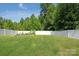 Expansive, lush backyard featuring a white vinyl fence, vibrant green grass, and mature trees, perfect for outdoor enjoyment at 389 Whispering Hills Dr, Locust, NC 28097