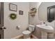 Stylish half bathroom featuring modern fixtures, decorative wall art, and pedestal sink at 389 Whispering Hills Dr, Locust, NC 28097