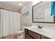 Well-lit bathroom featuring a dark wood vanity, framed mirror, and shower with curtain at 389 Whispering Hills Dr, Locust, NC 28097