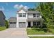Charming two-story home with a well-maintained lawn, two car garage, and inviting front porch with swing at 389 Whispering Hills Dr, Locust, NC 28097