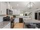 Modern kitchen with granite countertops, stainless appliances, and a view of the living room at 389 Whispering Hills Dr, Locust, NC 28097