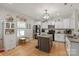 Well-lit kitchen featuring white cabinetry, stainless steel appliances, and a gray kitchen island at 389 Whispering Hills Dr, Locust, NC 28097