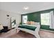 Main bedroom featuring a green accent wall, plush bedding, and stylish decor at 389 Whispering Hills Dr, Locust, NC 28097