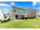 A spacious backyard with a concrete patio, outdoor seating, and a well-maintained lawn at 4732 Gibbons Link Rd, Charlotte, NC 28269