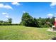 An expansive backyard featuring lush green grass, mature trees, and a partial view of patio seating at 4732 Gibbons Link Rd, Charlotte, NC 28269