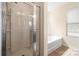 Bright bathroom features a glass-enclosed shower and a soaking tub with natural light at 4732 Gibbons Link Rd, Charlotte, NC 28269