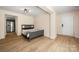 Cozy bedroom features gray wood-style floors, a comfortable bed, and stainless steel refrigerator in ajoining area at 4732 Gibbons Link Rd, Charlotte, NC 28269