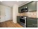 Modern kitchen equipped with stainless steel appliances, stylish cabinetry, and updated flooring at 4732 Gibbons Link Rd, Charlotte, NC 28269