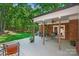 Covered deck with outdoor seating, brick facade, and a view of a wooded yard at 5008 Saddle Horn Trl, Weddington, NC 28104