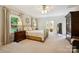 Spacious bedroom featuring neutral decor, carpet, and updated ceiling fan, with an ensuite bathroom at 5008 Saddle Horn Trl, Weddington, NC 28104