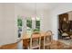 Cozy dining area with natural light, hardwood floors, a view of the outdoor patio, and a brick fireplace at 5008 Saddle Horn Trl, Weddington, NC 28104