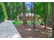 Beautiful brick home with a long driveway, lush landscaping, and mature trees surrounding the property, offering privacy at 5008 Saddle Horn Trl, Weddington, NC 28104