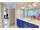 Bright bathroom with double vanity, modern lighting, large mirrors and a glass shower enclosure at 6313 Woodland Commons Dr, Charlotte, NC 28269