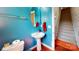 Bathroom featuring a vessel sink, blue walls, oval mirror, and a view of the staircase at 6313 Woodland Commons Dr, Charlotte, NC 28269