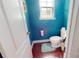 Powder room features a blue wall, window, toilet and hard wood flooring at 6313 Woodland Commons Dr, Charlotte, NC 28269