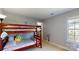A room features a bunk bed, neutral paint, and natural light from a large window at 6313 Woodland Commons Dr, Charlotte, NC 28269