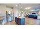 Open concept kitchen that flows into the living room, featuring an island and stainless steel appliances at 6313 Woodland Commons Dr, Charlotte, NC 28269