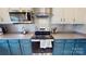 Modern kitchen showcasing stainless steel appliances, decorative backsplash, and blue cabinets with gold hardware at 6313 Woodland Commons Dr, Charlotte, NC 28269