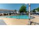 Community pool with lounge chairs, mature shade trees, and a gazebo in a residential area at 6313 Woodland Commons Dr, Charlotte, NC 28269