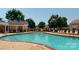 Community pool area featuring lounge chairs, mature trees, and a covered shelter with seating at 6313 Woodland Commons Dr, Charlotte, NC 28269