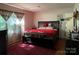 Comfortable bedroom with hardwood floors, a large bed, and sheer curtains allowing natural light at 6708 Nutcracker Pl, Charlotte, NC 28212