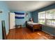Bright bedroom featuring hardwood floors, blue walls, and a charming, naturally lit space at 6708 Nutcracker Pl, Charlotte, NC 28212