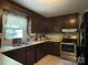 Functional kitchen featuring dark wood cabinets, stainless steel appliances, and tile floors at 6708 Nutcracker Pl, Charlotte, NC 28212