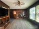 Gathering room with a brick fireplace, wood-paneled walls, and a ceiling fan at 6708 Nutcracker Pl, Charlotte, NC 28212