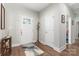Inviting foyer with wood-look floors, decorative rug, and a coat rack next to the front door at 7516 O'Hara St, Huntersville, NC 28078