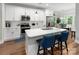 Bright kitchen with white cabinets, stainless steel appliances, and a central island with breakfast bar at 7516 O'Hara St, Huntersville, NC 28078
