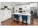 Modern kitchen with white cabinets, quartz countertops, stainless steel appliances, and bar seating at 7516 O'Hara St, Huntersville, NC 28078