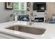 Close-up of a stainless steel kitchen sink with a modern faucet and white quartz countertops at 7516 O'Hara St, Huntersville, NC 28078