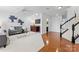 Cozy living room with hardwood floors, a gray sofa, and staircase at 7612 Turley Ridge Ln, Charlotte, NC 28273