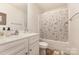 Bathroom with white vanity, patterned shower curtain, and ample lighting at 8330 Kneller St, Charlotte, NC 28215