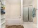 Bright bathroom featuring a tub, glass shower, and open shelving at 8330 Kneller St, Charlotte, NC 28215