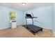 Bright bedroom featuring a treadmill, large window, and light blue walls at 8330 Kneller St, Charlotte, NC 28215
