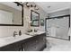 Modern bathroom featuring double sinks, sleek black fixtures, and a glass-enclosed shower at 9141 Covey Hollow Ct, Charlotte, NC 28210