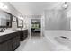 Open bathroom featuring double vanities, a soaking tub, and a glass-enclosed shower at 9141 Covey Hollow Ct, Charlotte, NC 28210