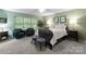 Inviting bedroom with plush seating area, large windows, and neutral color scheme at 9141 Covey Hollow Ct, Charlotte, NC 28210