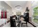 Formal dining room showcasing a glass table, piano, modern chandelier, and a glimpse of the home's interior at 9141 Covey Hollow Ct, Charlotte, NC 28210