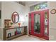 Bright entryway featuring a decorative red front door, console table, and tile flooring at 9141 Covey Hollow Ct, Charlotte, NC 28210