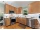 Well-lit kitchen featuring wooden cabinets, stainless steel appliances, and a window with a view at 9141 Covey Hollow Ct, Charlotte, NC 28210