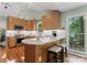 Modern kitchen with a countertop bar, stainless steel appliances, and light wood cabinets at 9141 Covey Hollow Ct, Charlotte, NC 28210